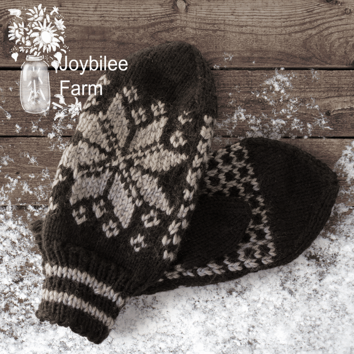 grey knit mittens on a wood and snow background