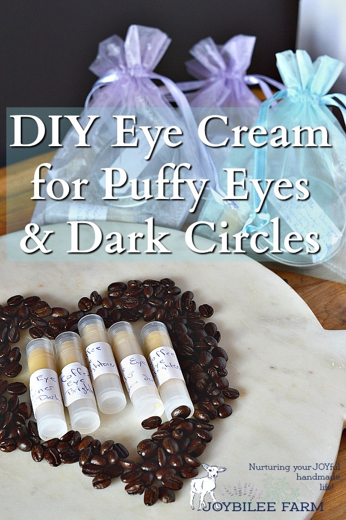Coffee eye cream in tubes on a plate surrounded with coffee beans, and with gift bags in the background.