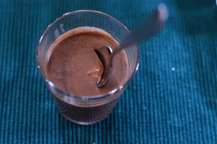 Chocolate panna cotta in a glass on a teal background