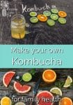 Citrus slices on a board by a glass of kombucha